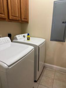 a laundry room with a washing machine and a washer at Penthouse Close to Disney area and Malls water view in Orlando