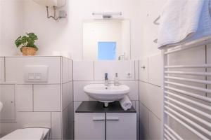 a white bathroom with a sink and a toilet at Apartments an der Universität in Wuppertal