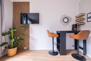 a room with a desk and two chairs and a television at Apartments an der Universität in Wuppertal