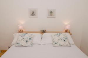 a bed with white sheets and pillows on it at Casa Rubina in Capri