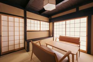 Cette chambre comprend une table, des chaises et des fenêtres. dans l'établissement Zenji 町家六堀, à Kyoto