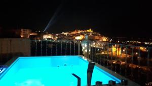 a swimming pool on a balcony at night at Biancadamare in Ostuni