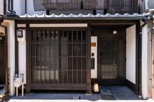 un accès à un bâtiment avec une porte dans l'établissement Zenji 町家六堀, à Kyoto