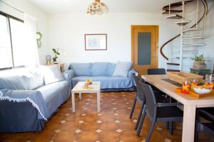 a living room with a blue couch and a table at Chalet Arena de Canelas en 1ª línea de Playa, Sanxenxo in Portonovo