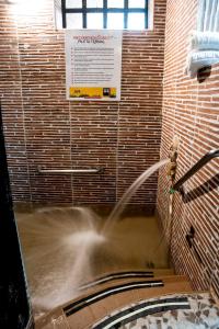 une fontaine dans une pièce avec un tuyau dans l'établissement Hotel Hacienda El Salitre, à Paipa