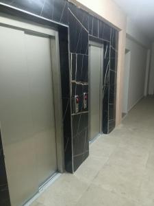 korytarz z dwoma drzwiami i ścianą wyłożoną kafelkami w obiekcie House for rent for family w mieście Yomra