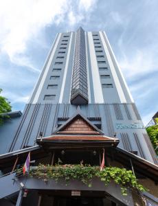 wysoki biały budynek z balkonem przed nim w obiekcie Pinnacle Lumpinee Park Hotel SHA Plus w mieście Bangkok