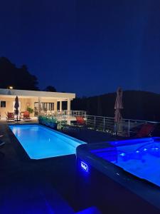 a swimming pool at night with a house at Les Hauts du Peireguier in La Motte