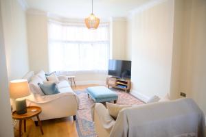 a living room with white furniture and a tv at Bridgnorth Town House in Bridgnorth