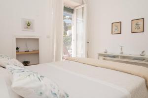 a white bedroom with a bed and a window at Casa Rubina in Capri
