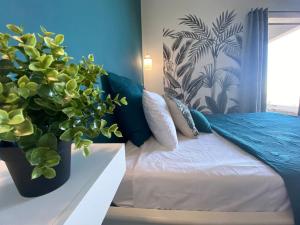 um quarto com uma cama com dois vasos de plantas em Cocoon Love avec piscine privative em Saint-Louis