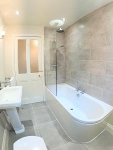 a bathroom with a tub and a toilet and a sink at Bridgnorth Town House in Bridgnorth