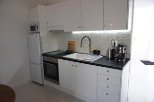 una cucina bianca con lavandino e frigorifero di Casa Amélia a Feteira Grande