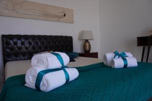 Dos pilas de toallas en una cama en una habitación en Casa Amélia, en Feteira Grande