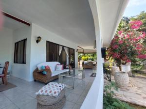 een woonkamer met een tafel en stoelen op een patio bij Reef Hills Residence FAMILY HOME in Au Cap