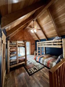 a log cabin bedroom with two bunk beds at Abundant Acres Retreat in Beech Mountain
