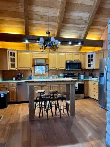 a kitchen with wooden cabinets and a large island with bar stools at Abundant Acres Retreat in Beech Mountain