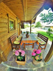 un patio con mesa, bancos y flores en Lodge Bled en Bled