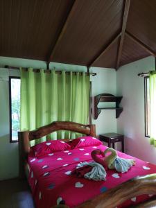 圖納里鎮的住宿－Hotel Mirador Villa Tunari，一间卧室配有一张带粉红色床单的大床