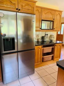 a kitchen with a stainless steel refrigerator and wooden cabinets at Grace's Landing in Sneem