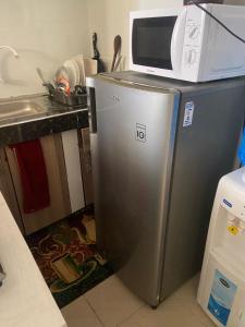 a microwave sitting on top of a refrigerator in a kitchen at Davkin Apartments in Mombasa