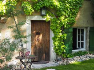 une maison avec une porte en bois et des vignes dans l'établissement Les Gîtes du Domaine de Rhodes, à Avignon