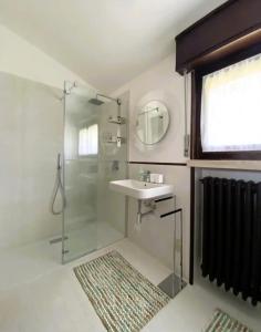 a bathroom with a glass shower and a sink at VILLA SETTANTA Lago di Garda - Heated Pool on request in Bardolino