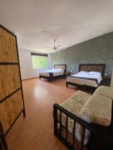 una camera con tre letti di Tonantzincalli SPA Prehispanico a Chiconcuac