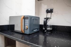 eine Mikrowelle auf einer Theke in einer Küche in der Unterkunft Executive 3-Bed Furnished Apartment in Kwashieman in Accra