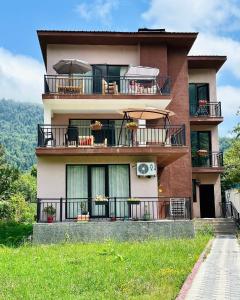 un edificio con balcones, mesas y sillas. en Green Mountain Borjomi, en Borjomi 54 fotos más