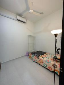 Habitación con cama y lámpara. en Syakila Homestay en Marang