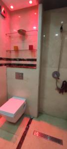 baño con aseo blanco en una habitación roja en Appt de standing (mer et forêt), en Tánger