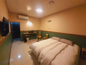 um quarto com uma cama grande e uma secretária em Lilyfarm B&B em Yuli