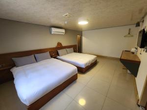 um quarto de hotel com duas camas e uma secretária em Lilyfarm B&B em Yuli