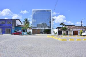 a large glass building with a car parked in front of it at Goiana Palace Hotel - Perto da JEEP, KLABIN, HEMOBRÁS, VIVIX in Goiana
