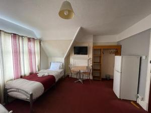 Kleines Zimmer mit 2 Betten und einem Kühlschrank. in der Unterkunft ST NICHOLAS HOTEL in Kenton