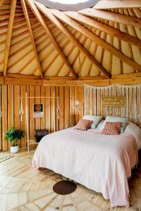 1 dormitorio con cama grande en el techo de madera en La Belle Ronde, 