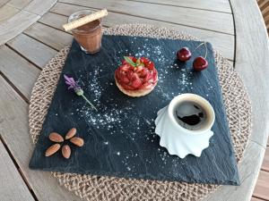una mesa con un plato de comida y una taza de café en La Belle Ronde, 