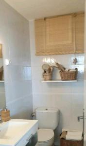 La salle de bains blanche est pourvue de toilettes et d'un lavabo. dans l'établissement PRECIOSO APARTAMENTO VISTAS AL MAR, à Platja d'Aro