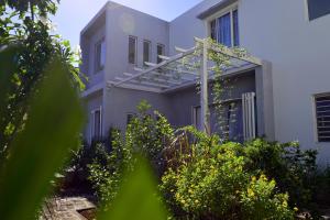 ein weißes Haus mit einem Garten davor in der Unterkunft Mahebourg Family Home in Mahébourg