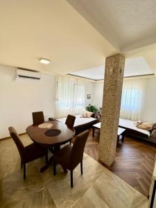 a living room with a table and chairs and a couch at Montenegrina Apartment in Budva