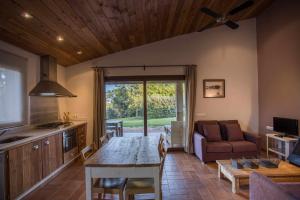 a kitchen and living room with a table and a couch at Mas Garriga Turisme Rural in Girona