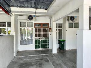 a white garage with doors and a green trash can at Adempuri Homestay 3 in Jitra