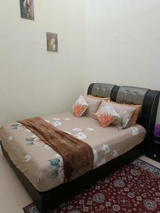 a bed with pillows on it in a room at Adempuri Homestay 3 in Jitra