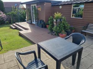 un patio con mesa, sillas y banco en Ann's Garden flat, en Deganwy
