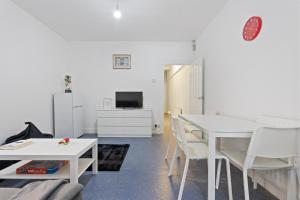 een woonkamer met een witte tafel en witte stoelen bij Fantastic 2BD Barking stay with links to the City! in Londen