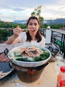 una donna che mangia cibo da una grande ciotola di cibo di บ้านแช่มช้อย 360 a Khao Kho Altre 17 foto