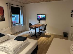 Dormitorio con escritorio, cama y TV en SleepOver in Rødby! Few minutes from Femern Tunnel and Ferry to Puttgarden, en Rødby