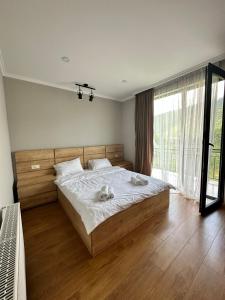 a bedroom with a large bed with two towels on it at Green Mountain Borjomi in Borjomi +54 photos