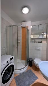 a bathroom with a shower and a washing machine at Happy Living Apartment w Balcony in Budapest